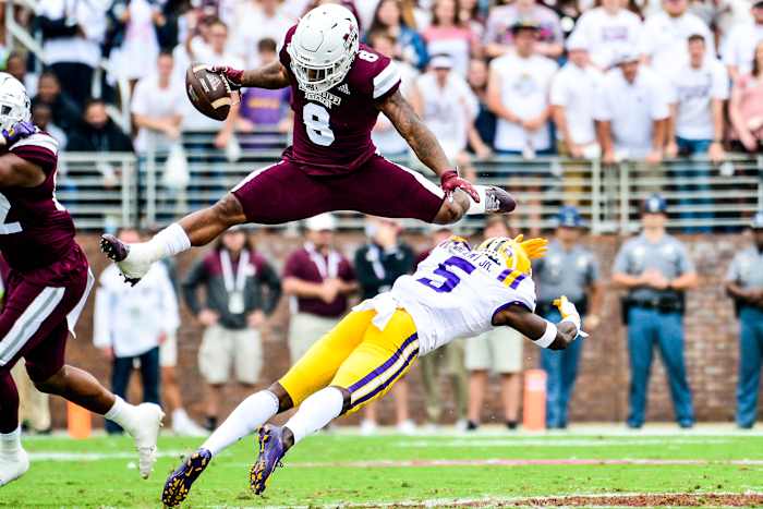 Kylin Hill hurdles an LSU defender during an SEC game